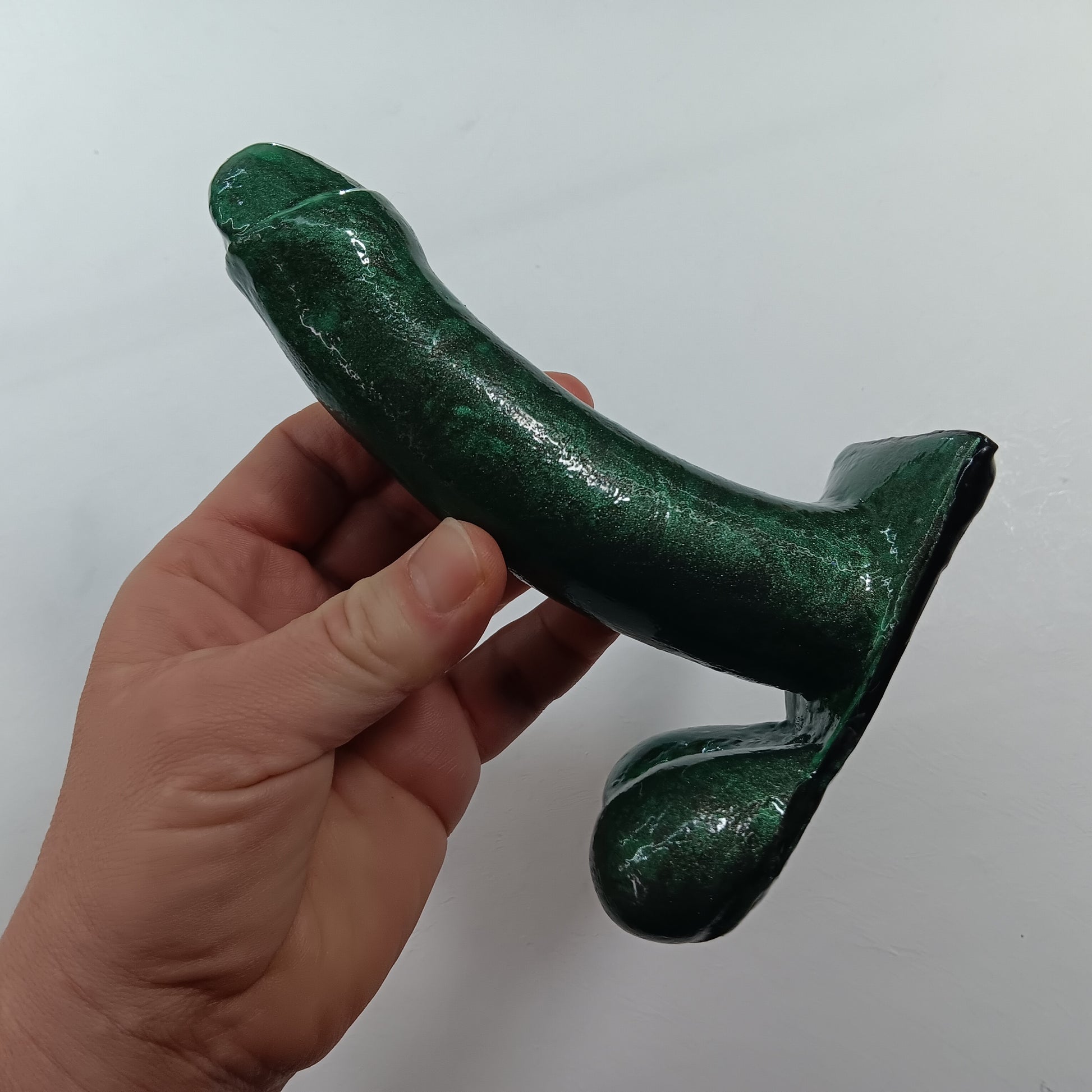 Hand holding the 5 inch SQUEEZE in green shimmer.