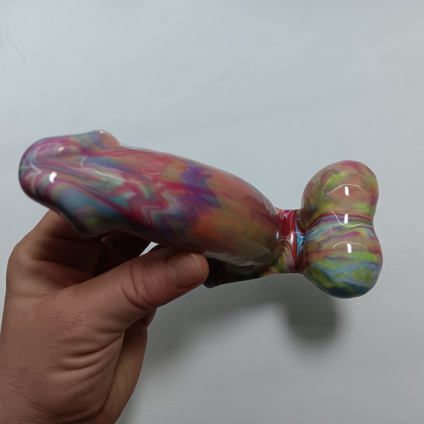 Hand holding the toy showing the view from the top down. The underside of the shaft and balls - they are connected by thin silicone that allows the balls to move.