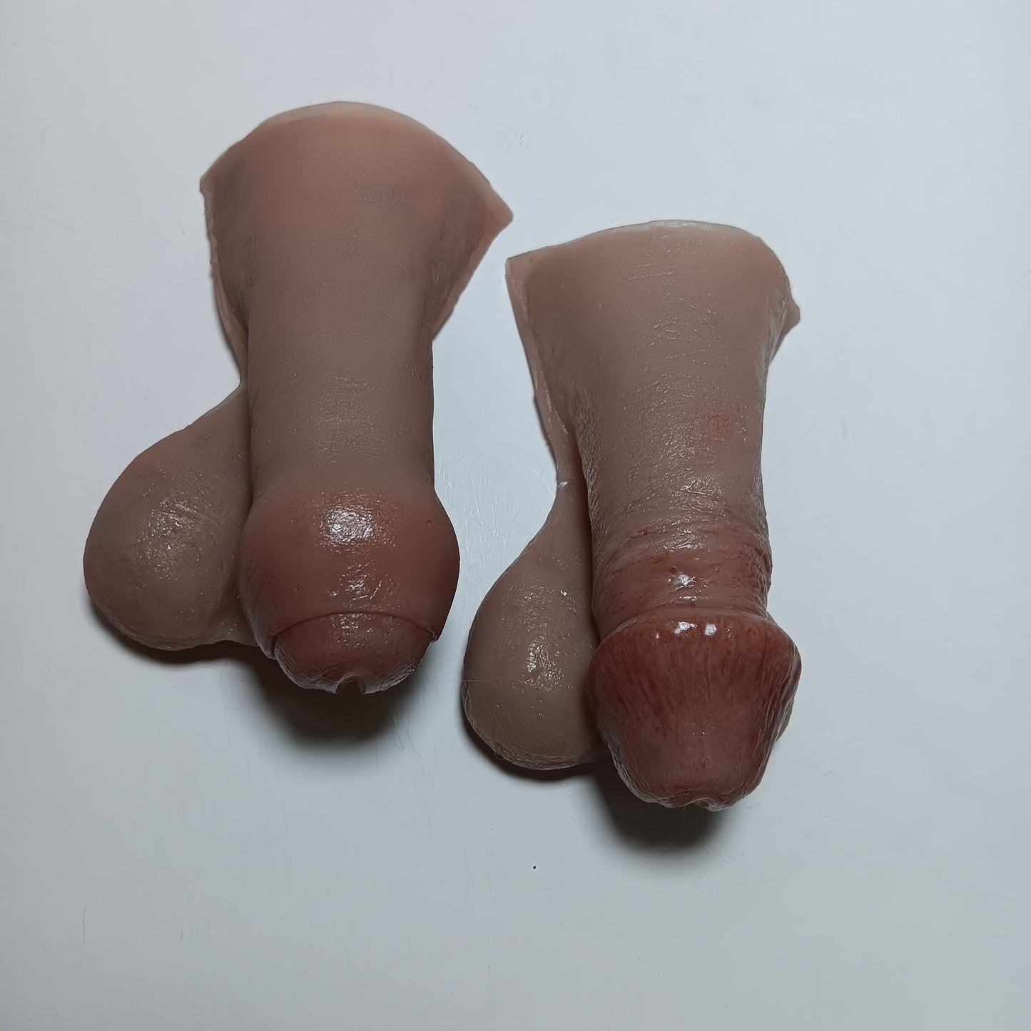 two 3 inch STP Skins show the style options choices for circumcised and uncircumcised in realistic fully painted lifelike silicone prosthetic.