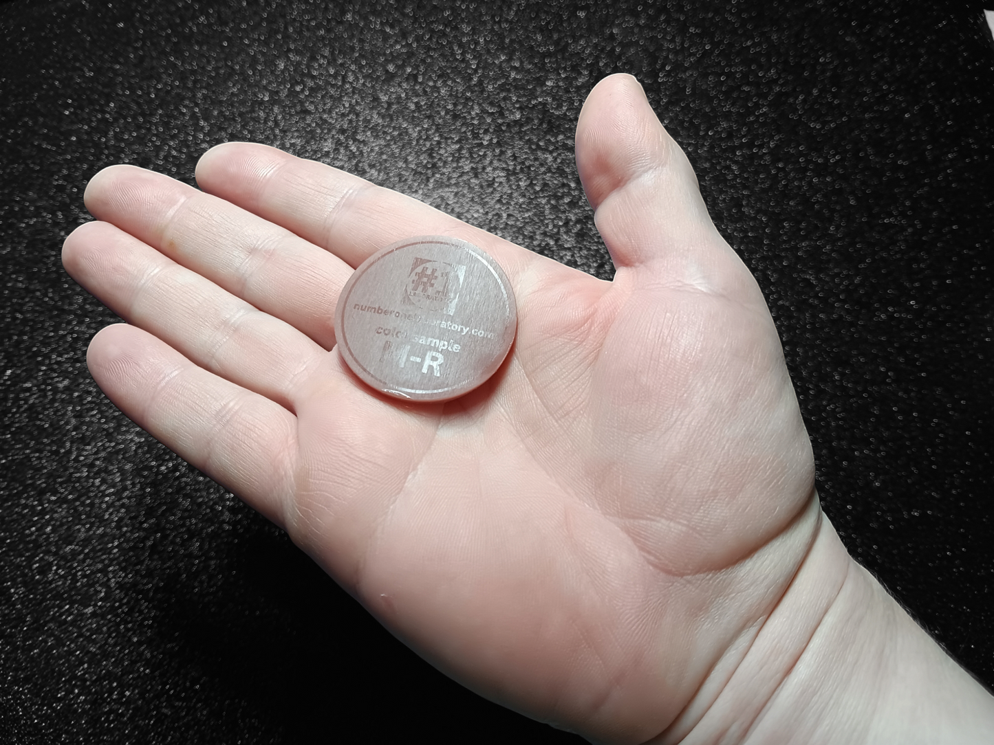 Image of color sample in hand, it's the size of a large coin