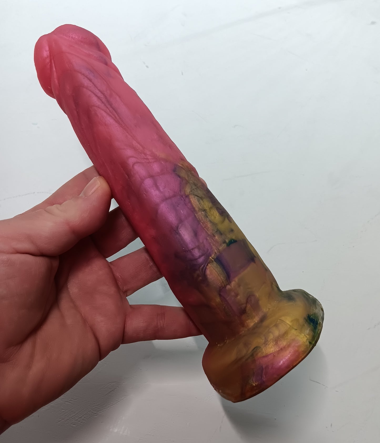 the underside of unique pour pink and gold B.J. suction dildo