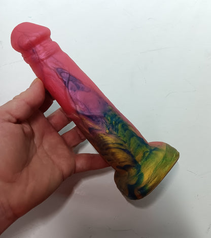 Top view of the pink and gold dildo showing swirls of blue and gold around the base while the head is bright hot pink.